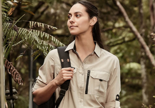 woman walking in the bush with a backpack and work shirt